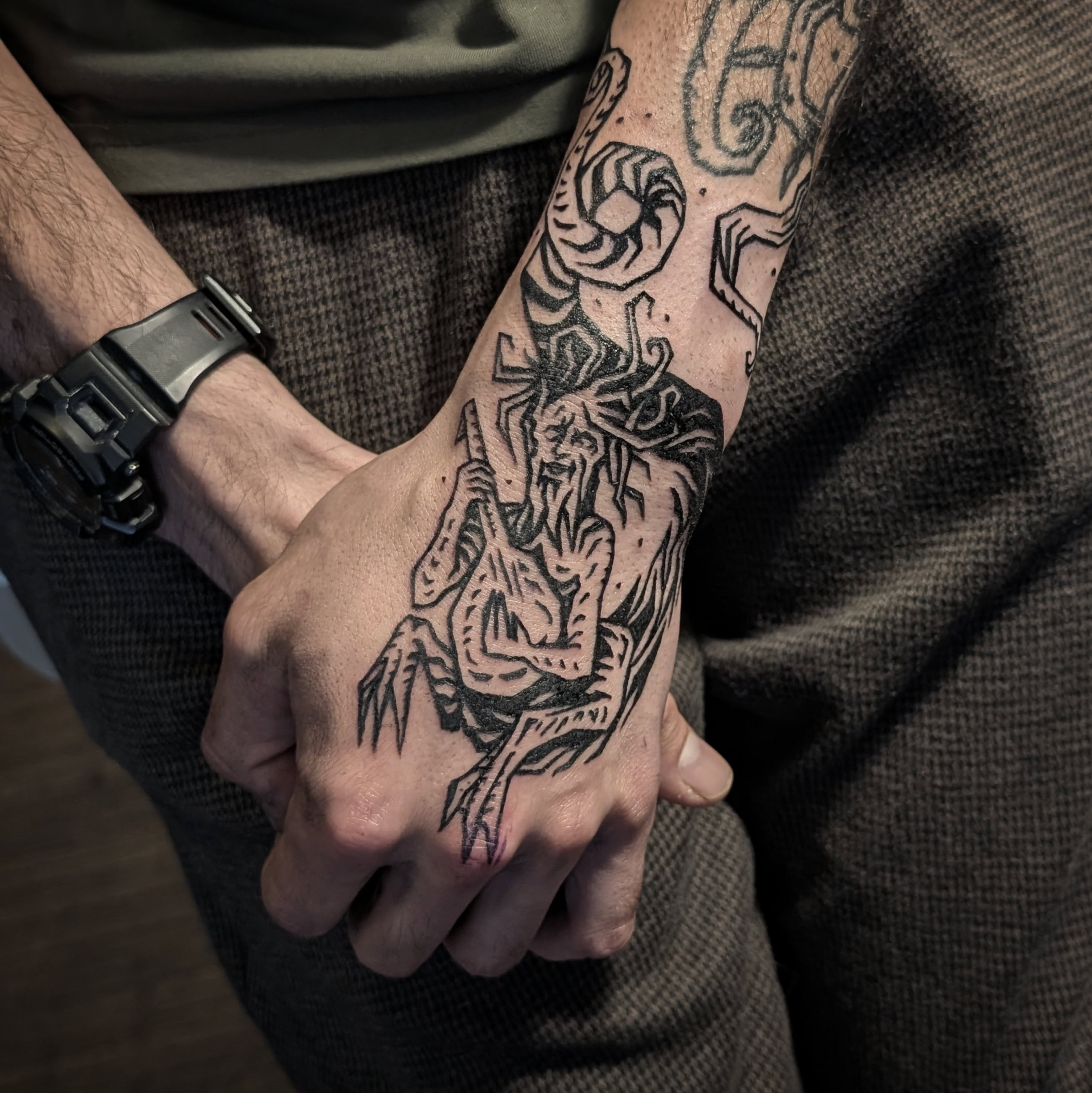 Démon cornu tatoué sur la main, style gravure